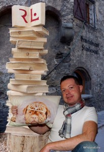 Kollege Roland Hölzl mit Bücherturm und Hundepolster
